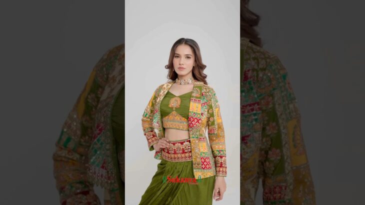 An olive green draped ensemble paired with a vibrant embroidered jacket.